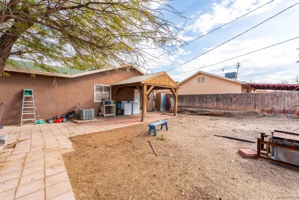 a backyard of a house with barbeque oven table and chairs