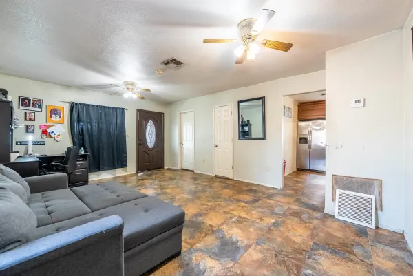 a living room with furniture and a ceiling fan