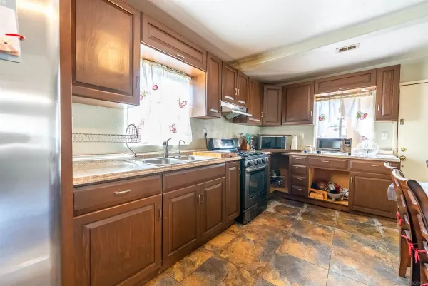 a kitchen with kitchen island granite countertop a stove a sink and a refrigerator