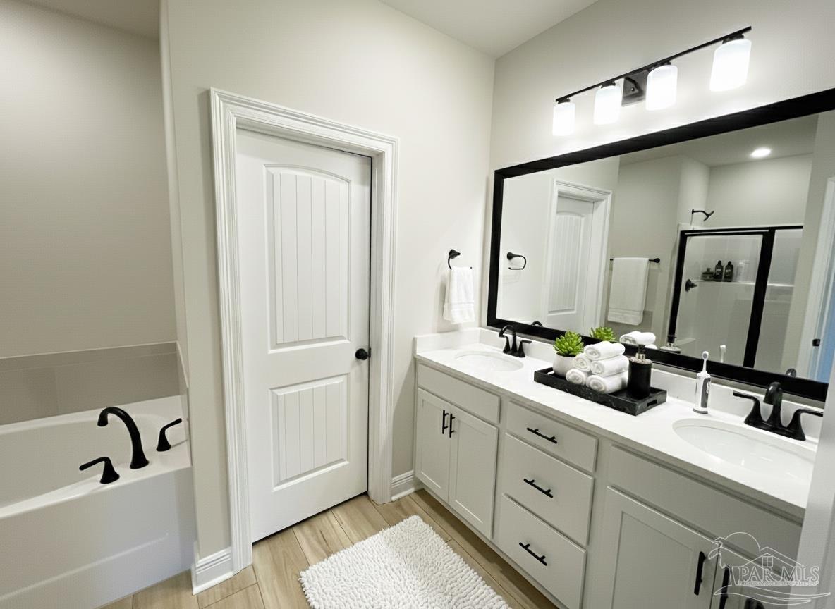 7950 Klondike Road, Unit 25 Pensacola, FL 32526 - Photo 4 of 6 a bathroom with a double vanity sink and mirror with bathtub
