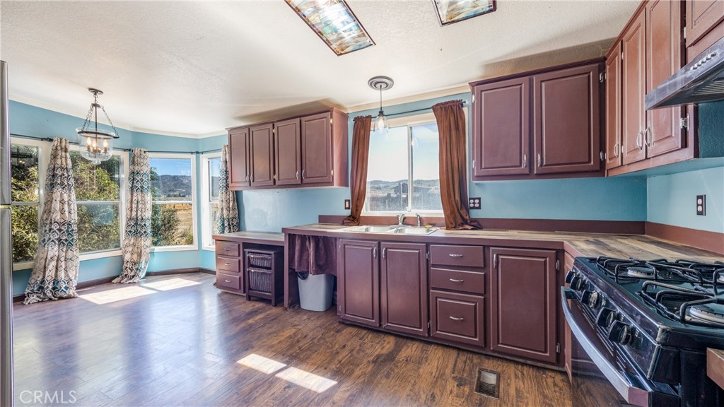 39550 Kirby Road Anza, CA 92539 - Photo 4 of 53 a kitchen with stainless steel appliances granite countertop a stove a sink dishwasher a microwave oven and a dining table with wooden floor