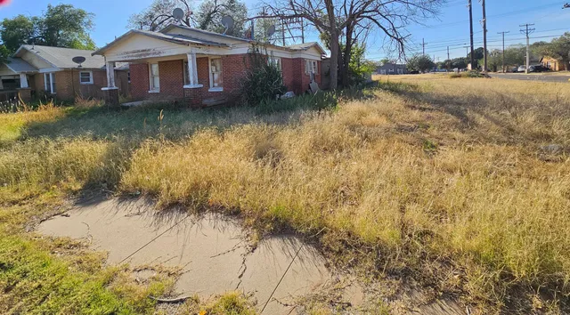 a view of a house with a yard next to a lake