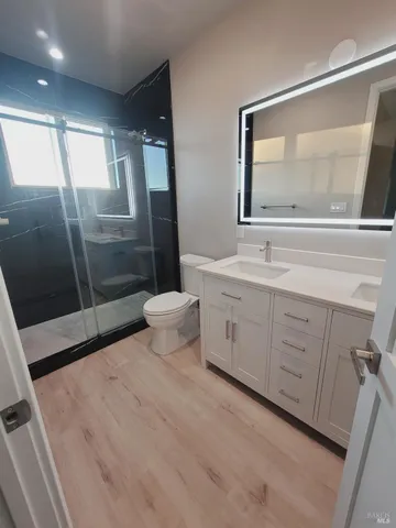 a bathroom with a double vanity sink toilet mirror and window