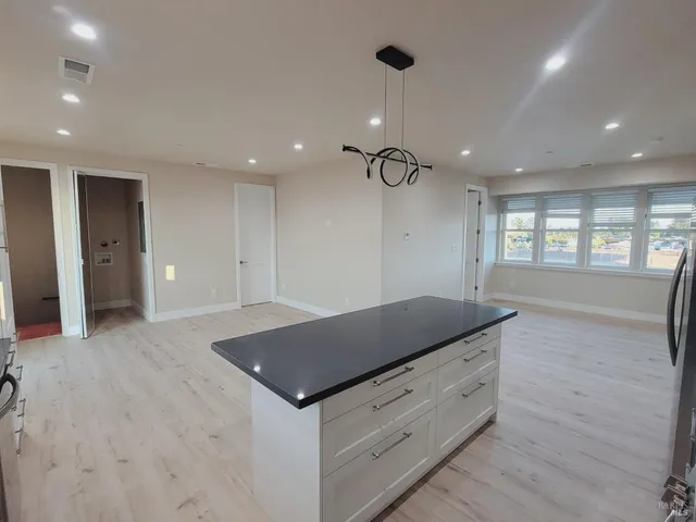 a kitchen with granite countertop white cabinets and window