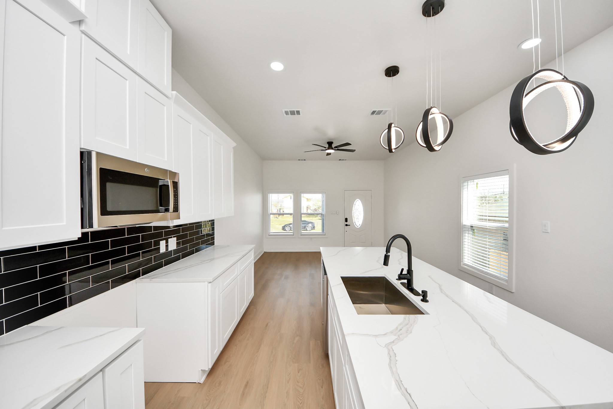 5226 Ricky Street Houston, TX 77033 - Photo 15 of 50 a kitchen with granite countertop a stove a sink and a microwave
