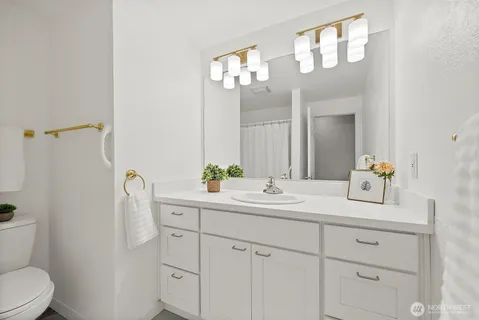 a bathroom with a sink a toilet and a mirror