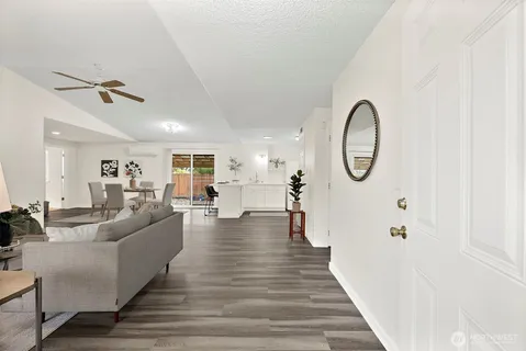 a living room with furniture a mirror and white walls