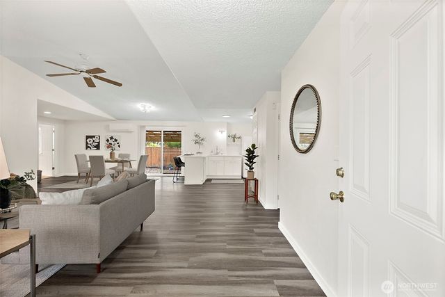 a living room with furniture a mirror and white walls