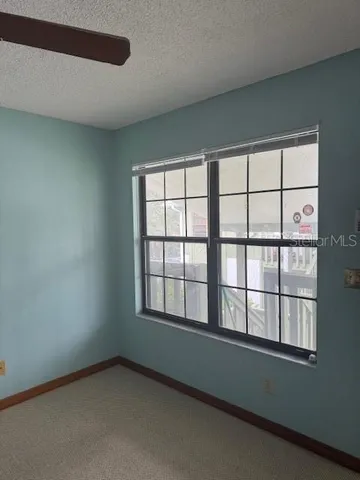 a view of a hallway with wooden floor and a bathroom