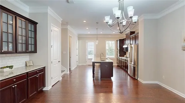 a view of a dining room with furniture a chandelier and wooden floor