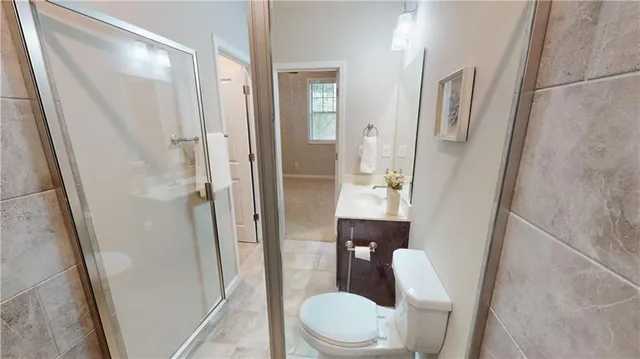 a bathroom with a sink a toilet a walk in closet