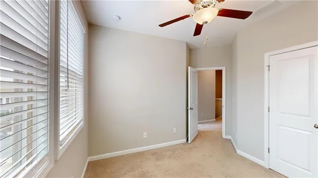 a view of a room with a ceiling fan and window