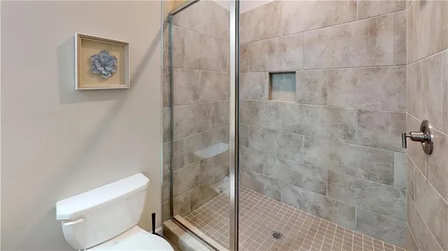 a bathroom with a toilet and a shower