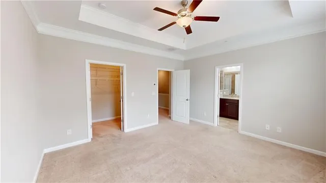 an empty room with closet and a ceiling fan