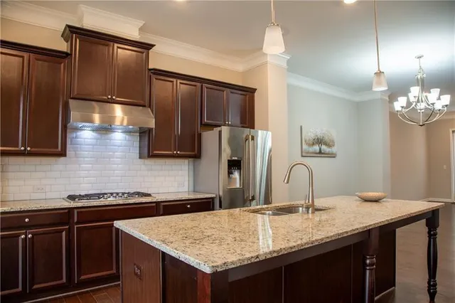 a kitchen with stainless steel appliances granite countertop a sink refrigerator and cabinets