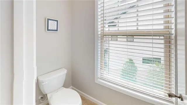 a bathroom with a toilet a sink and a window