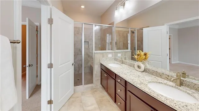 a bathroom with a granite countertop shower sink and a mirror