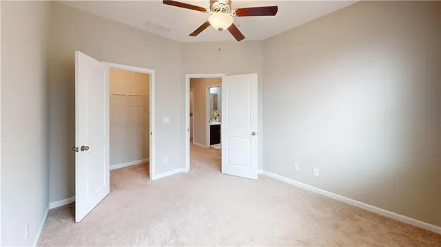 an empty room with chandelier fan and closet