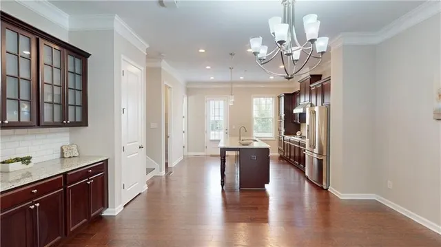 a view of a dining room with furniture a chandelier and wooden floor