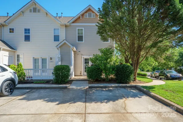 a front view of a house with a yard and potted plants