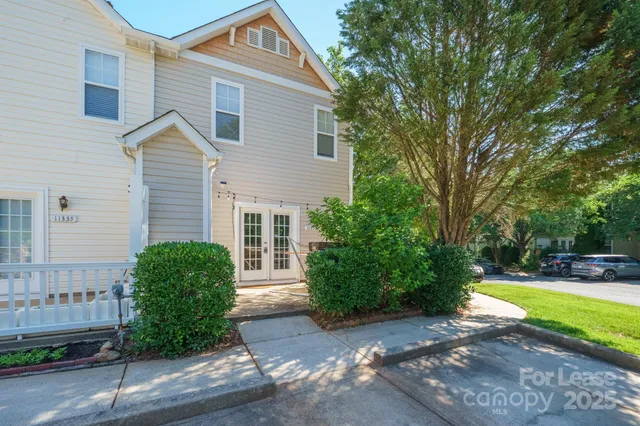 a view of a house with backyard and a tree