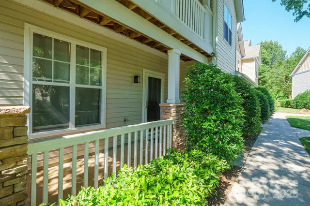 a view of a house with a small yard and flower plants