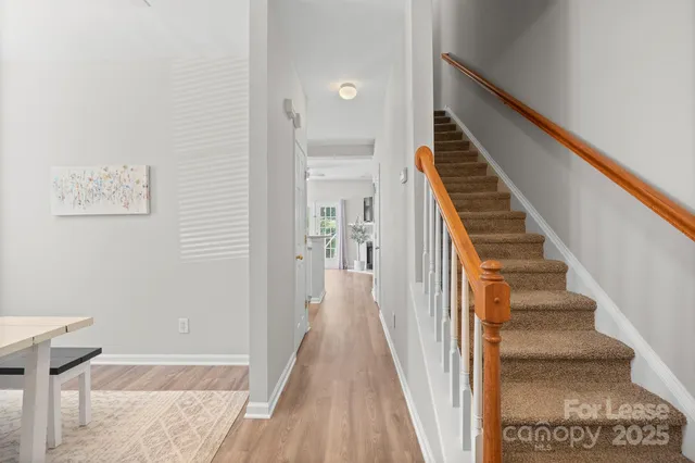 a view of a hallway with wooden floor and entryway