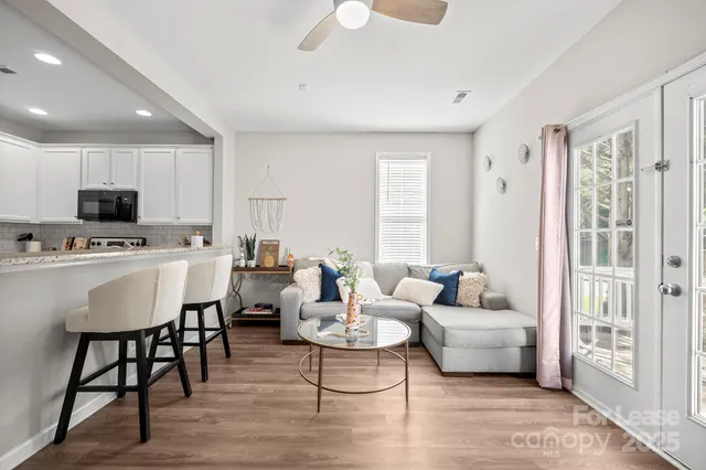 a living room with furniture and a dining table with kitchen view