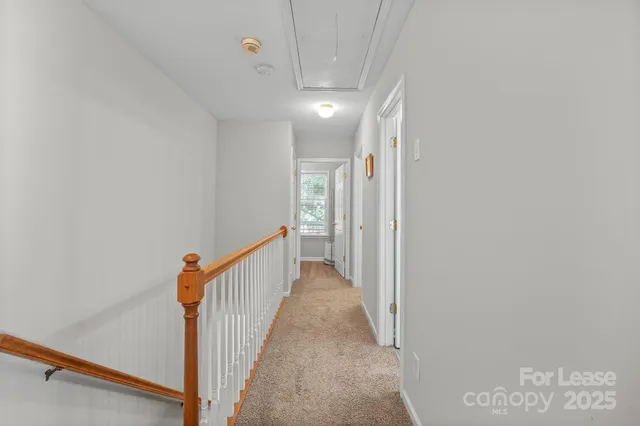 a view of a hallway with wooden floor and entryway