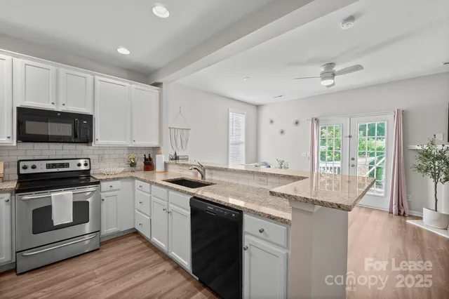 a kitchen with stainless steel appliances granite countertop a stove a sink and a microwave