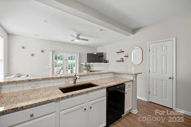 a kitchen with stainless steel appliances granite countertop a sink a stove and a microwave