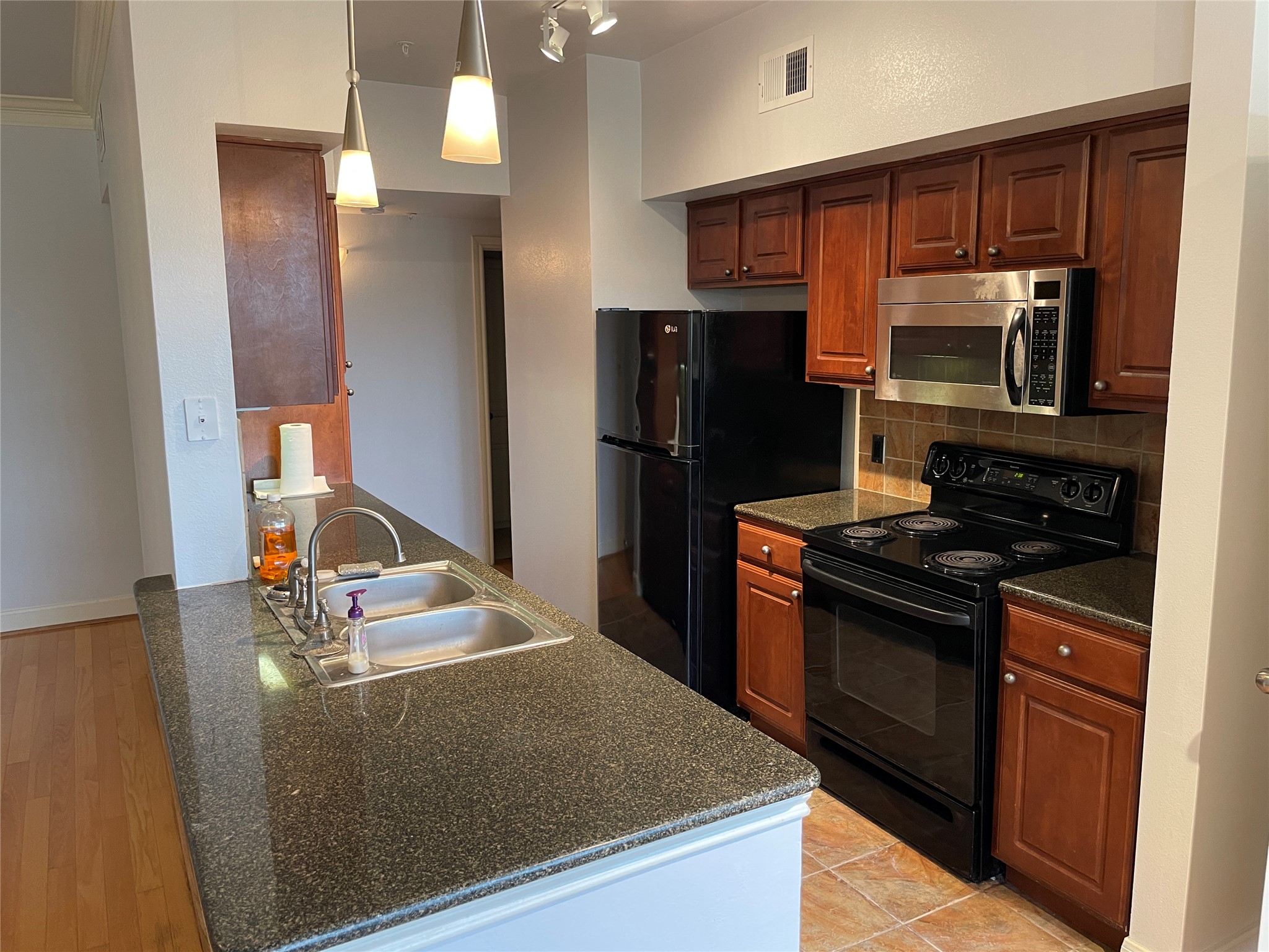 7701 Rialto Boulevard, Unit 822 Austin, TX 78735 - Photo 6 of 22 a kitchen with stainless steel appliances granite countertop a refrigerator stove and microwave