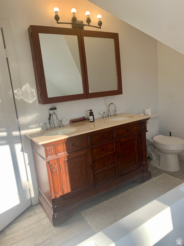 12645 East Cedar Ridge Drive Fairview, UT 84629 - Photo 17 of 25 Bathroom featuring double vanity, light wood-style floors, and vaulted ceiling