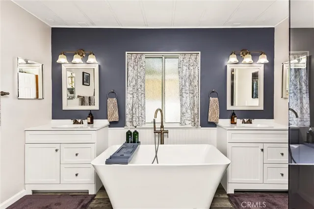 a large white bathroom with a sink a large mirror and a bathtub