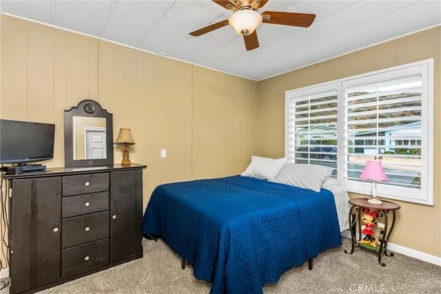 a bedroom with a bed and a flat tv screen on dresser