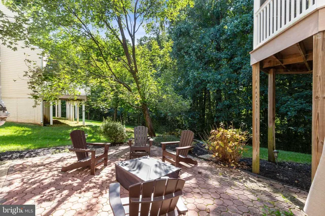 a view of a patio with table and chairs potted plants and large tree