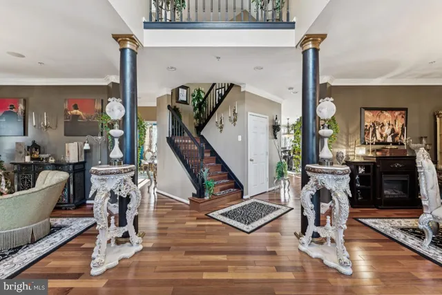 a view of a livingroom with furniture a fireplace wooden floor and windows