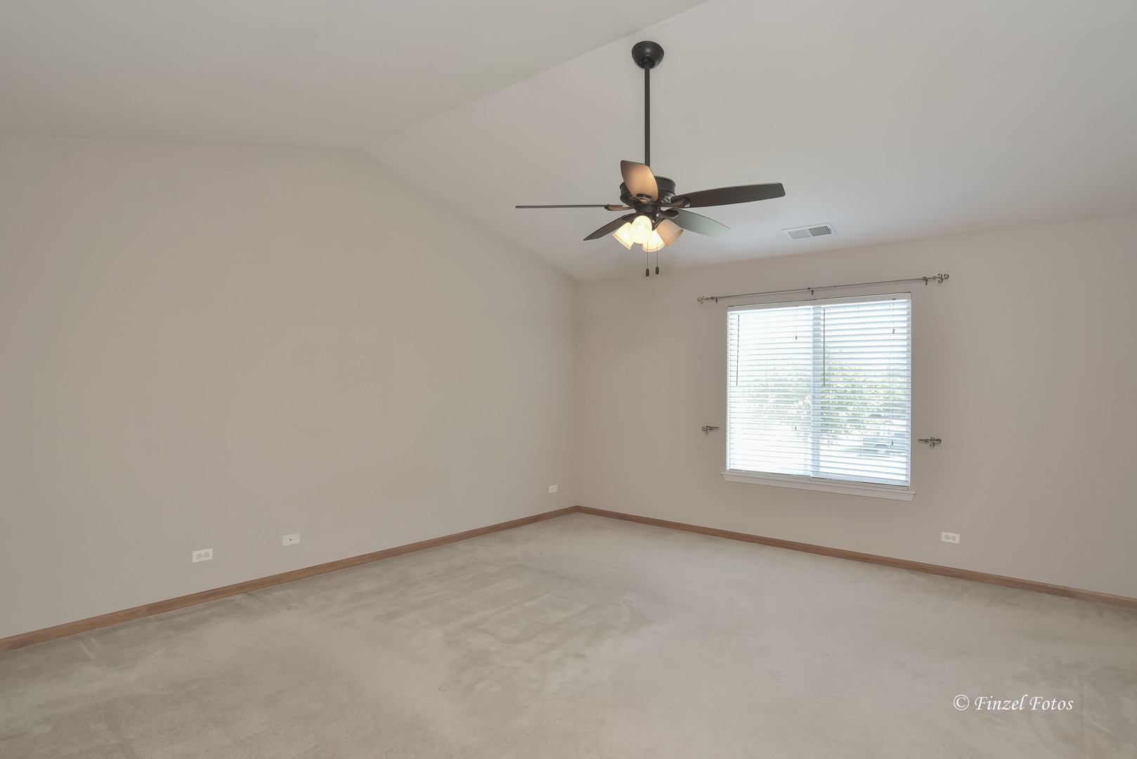 1931 South Cedar Lake Road Round Lake, IL 60073 - Photo 11 of 16 an empty room with a chandelier fan and windows