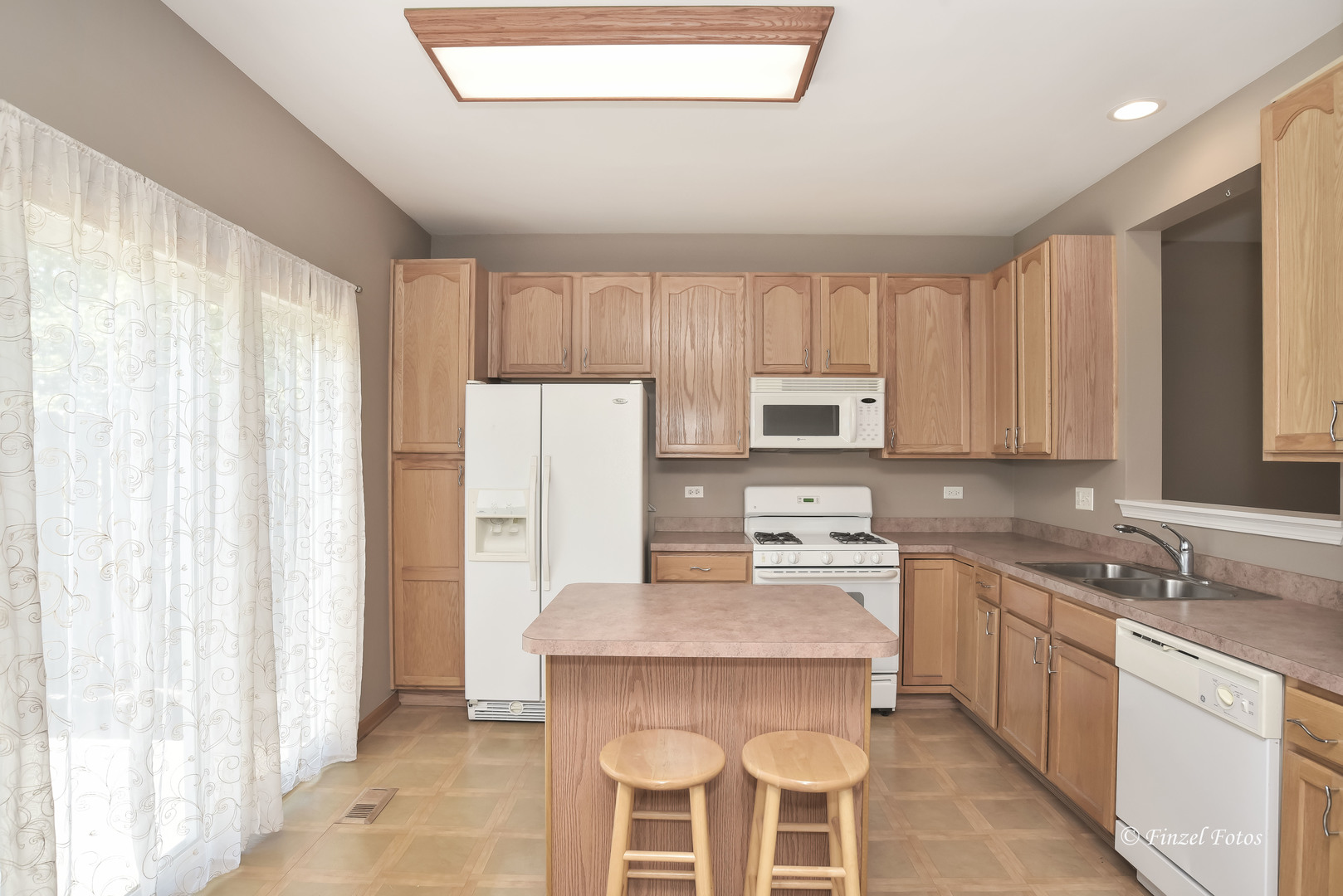 1931 South Cedar Lake Road Round Lake, IL 60073 - Photo 7 of 16 a kitchen with a refrigerator a stove a sink and dishwasher with wooden floor