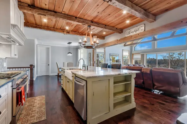 a living room with furniture a flat screen tv and a floor to ceiling window