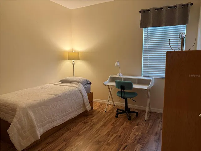 a bedroom with a bed a desk and chair