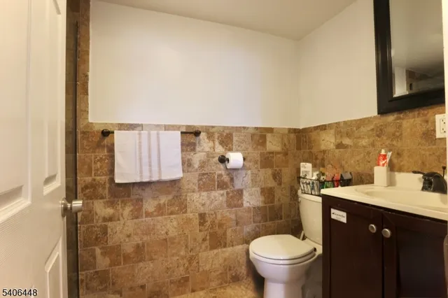 a bathroom with a granite countertop toilet and a sink