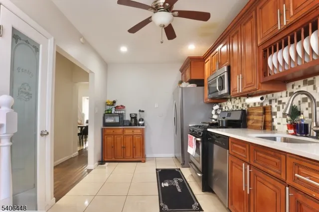 a kitchen with stainless steel appliances granite countertop a refrigerator a stove and a sink