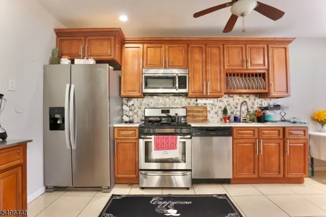 a kitchen with stainless steel appliances granite countertop a refrigerator and a stove top oven