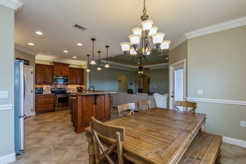 4595 Hermosa Road Crestview, FL 32539 - Photo 14 of 35 a dining room with wooden floor a chandelier a wooden table and chairs