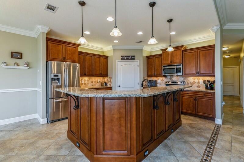 4595 Hermosa Road Crestview, FL 32539 - Photo 9 of 35 a kitchen with kitchen island granite countertop wooden cabinets a sink dishwasher a refrigerator and a stove