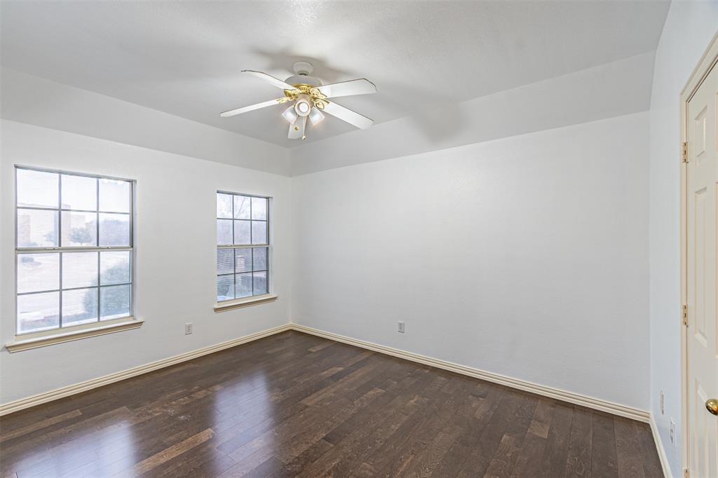 1907 New Haven Road Grapevine, TX 76051 - Photo 18 of 34 an empty room with wooden floor chandelier fan and windows
