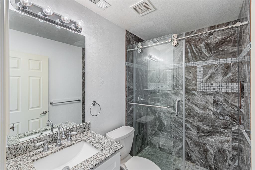 1907 New Haven Road Grapevine, TX 76051 - Photo 25 of 34 a bathroom with a granite countertop sink a toilet and shower