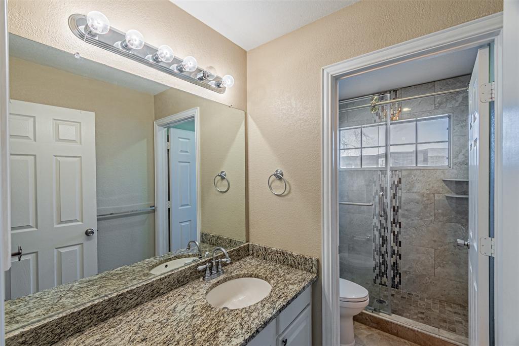 1907 New Haven Road Grapevine, TX 76051 - Photo 26 of 34 a bathroom with a granite countertop sink a mirror and shower