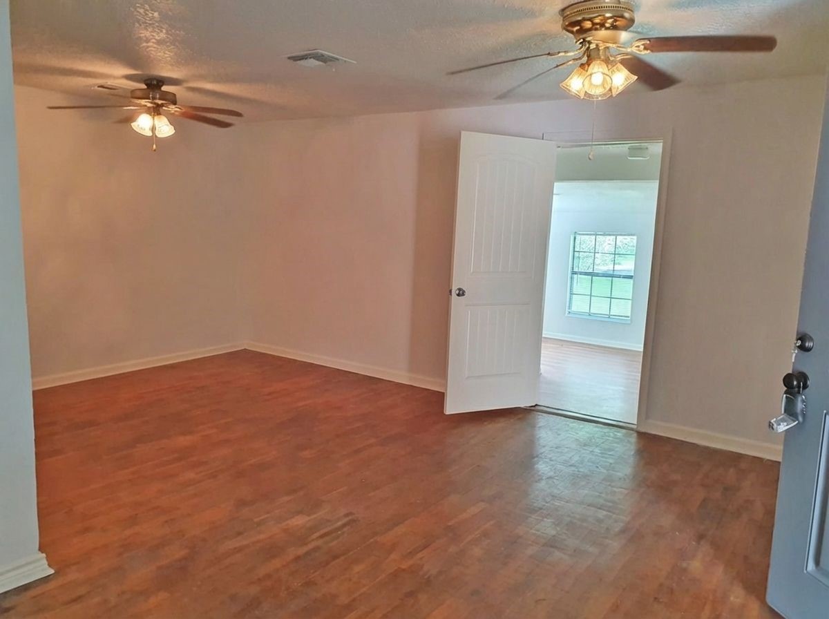 1272 Pecan Street Clute, TX 77531 - Photo 2 of 7 an empty room with windows and fan